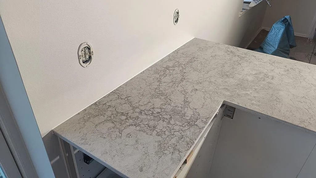 Närbild på installerad köksö i Caesarstone Moorland Fog, polerad, med synlig 20 mm kant i Malmö.