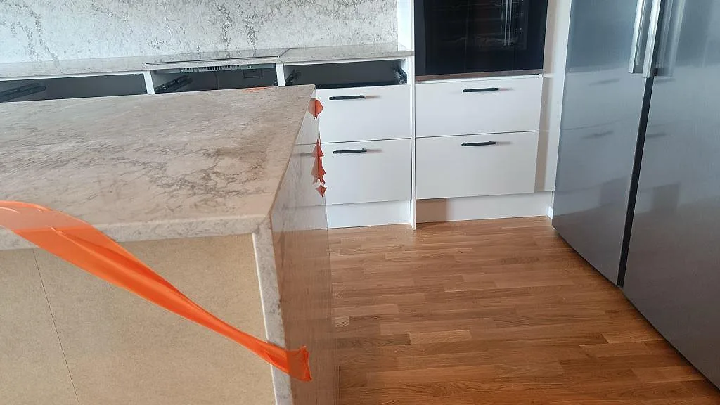 Köksö i polerad Caesarstone Moorland Fog med markerad kant och bakre bänkskiva i kök i Malmö.