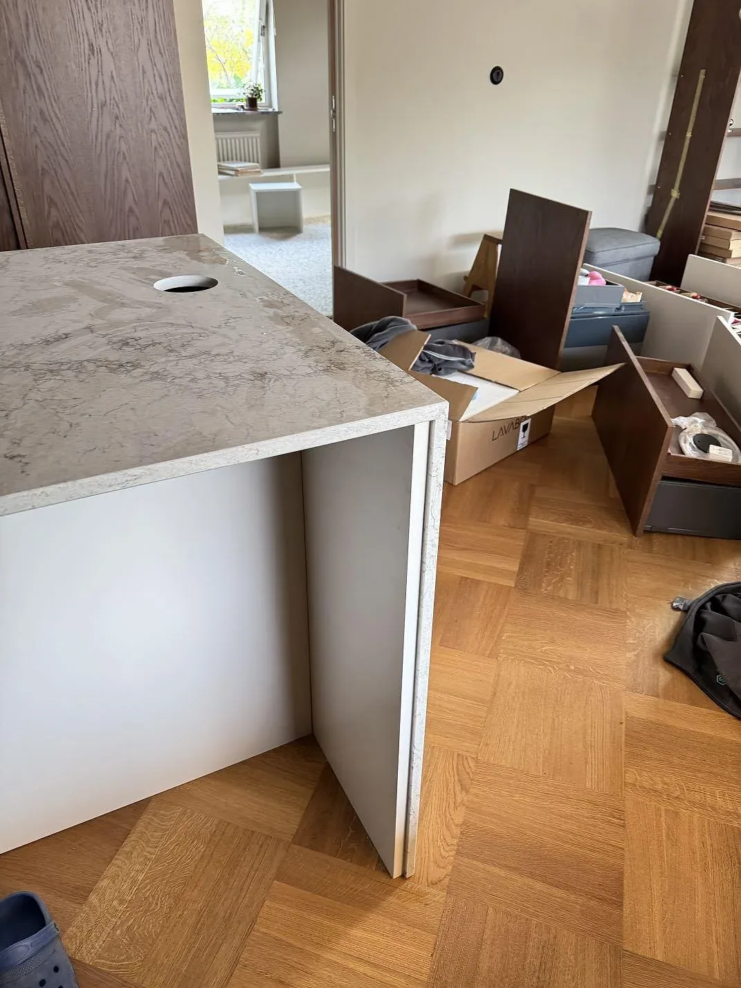 Sidovy av monterad arbetsyta i polerad Caesarstone Moorland Fog med ljus kvartskomposit, rund genomföring och parkettgolv i Malmö.