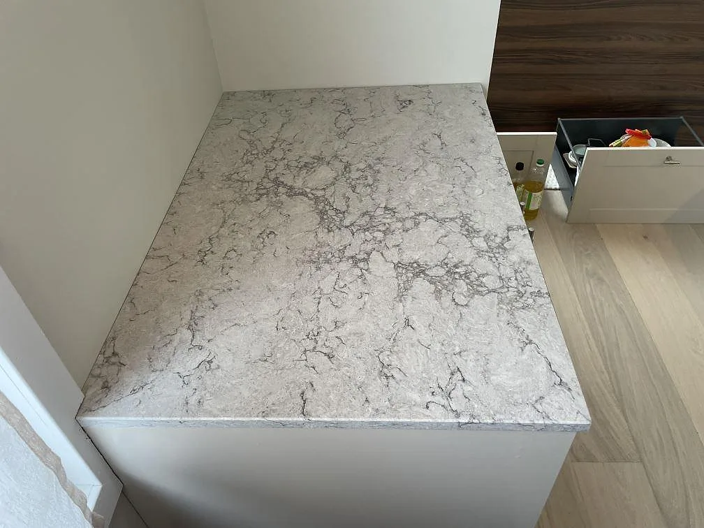 Närbild ovanifrån på den grå ådringen i polerad Caesarstone Moorland Fog köksbänkskiva i Saltsjö-Boo.