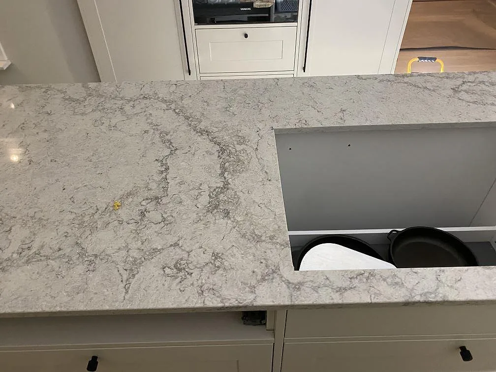 Närbild av köksö i Caesarstone Moorland Fog med polerad ljusgrå ådring och stor arbetsyta i Sandared.
