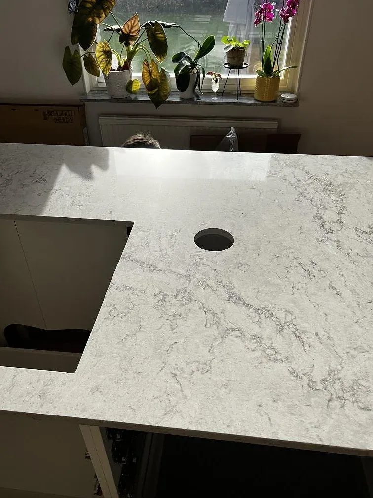 Detalj av köksö i Caesarstone Moorland Fog med urtag för diskho och kranhål i polerad kvartskomposit i Skurup.