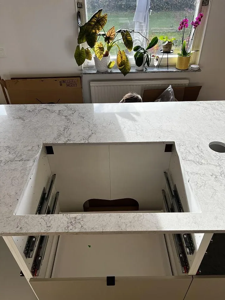 Närbild av urtag för svart diskho i Caesarstone Moorland Fog, polerad ljusgrå komposit på köksö i Skurup.