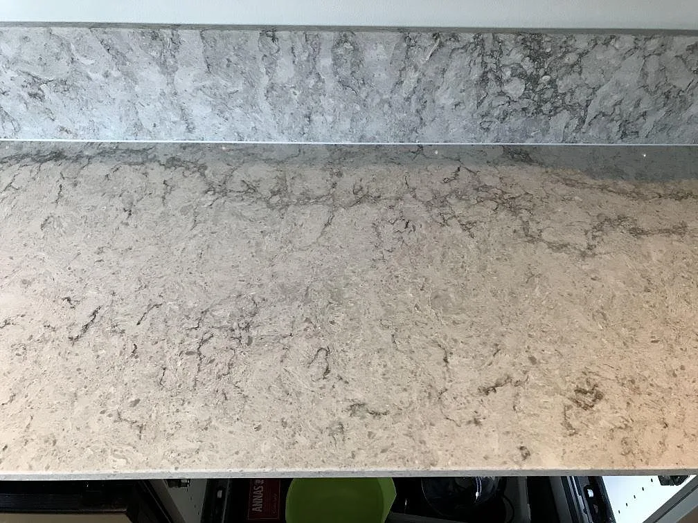 Närbild på den polerade ytan i Caesarstone Moorland Fog med mjuk grå ådring i ett kök i Västra Frölunda.