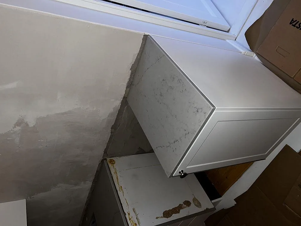 Detalj av monterad Caesarstone Noble Grey med polerad kant och vit köksstomme i Helsingborg.