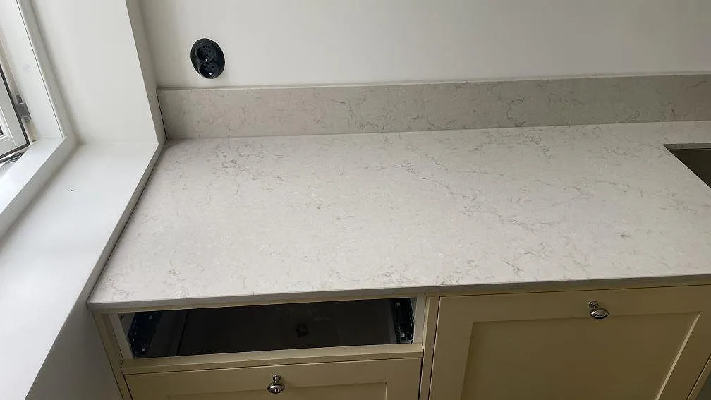 Väggbänk vid fönster i polerad Caesarstone Taj Royale 5212, ljus kvartskomposit med ådring och stänkkant i Höllviken.