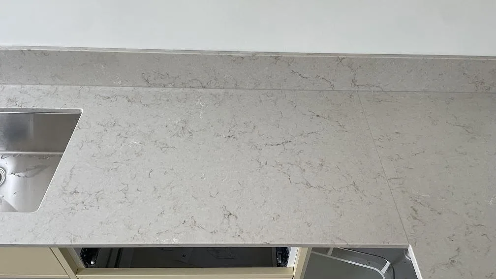 Detalj av Caesarstone Taj Royale 5212 i polerad komposit med diskhozon, stänkkant och ådrad bänkyta i Höllviken.
