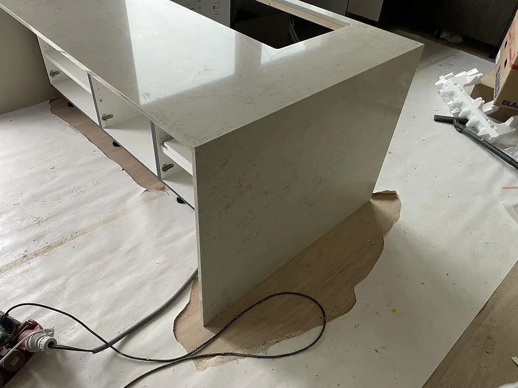Närbild på köksdel med vattenfallsida i Caesarstone Taj Royale 5212, polerad ljus komposit med ådring, i Nacka.