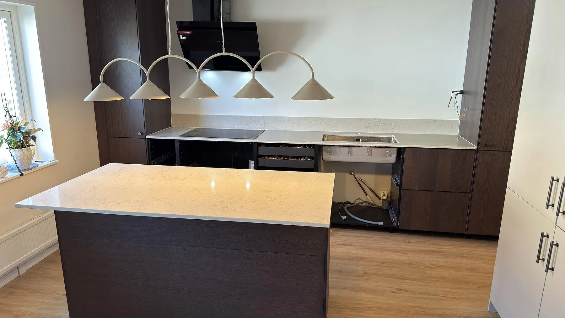 Kök i Norrköping med köksö och bänkskiva i beige Caesarstone Taj Royale 5212, induktionshäll och underlimmad rostfri diskho.