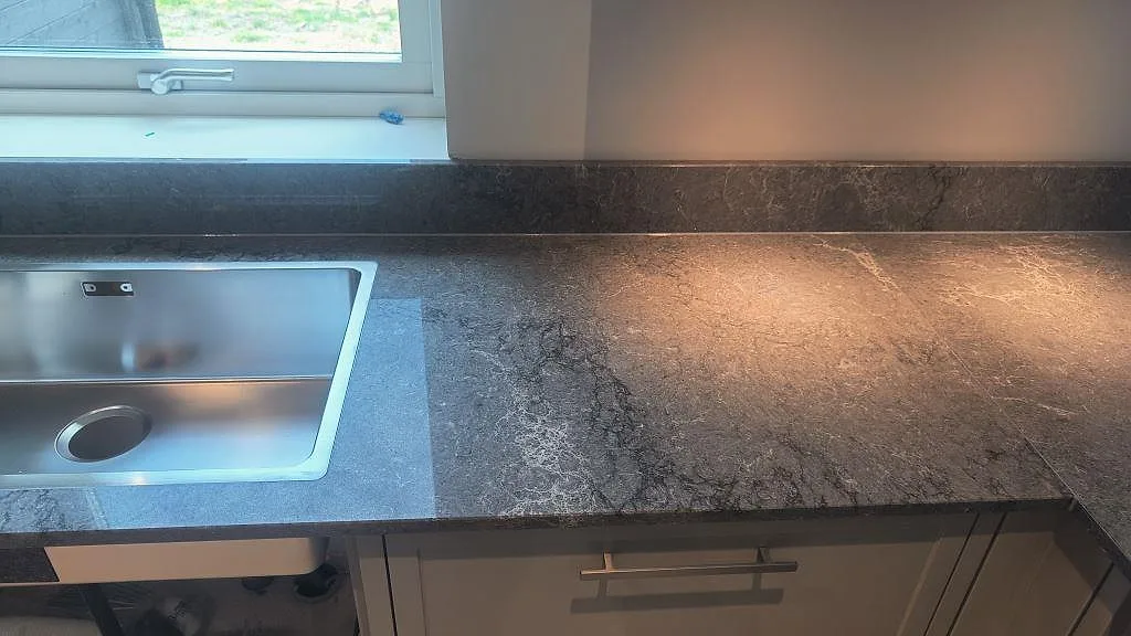 Diskbänk i polerad Caesarstone Turbine Grey komposit med rostfri diskho och uppvikt stänkkant i Alingsås.