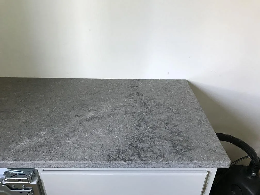 Köksbänkskiva i Caesarstone Turbine Grey monterad mot vägg under installation i ett kök i Göteborg.
