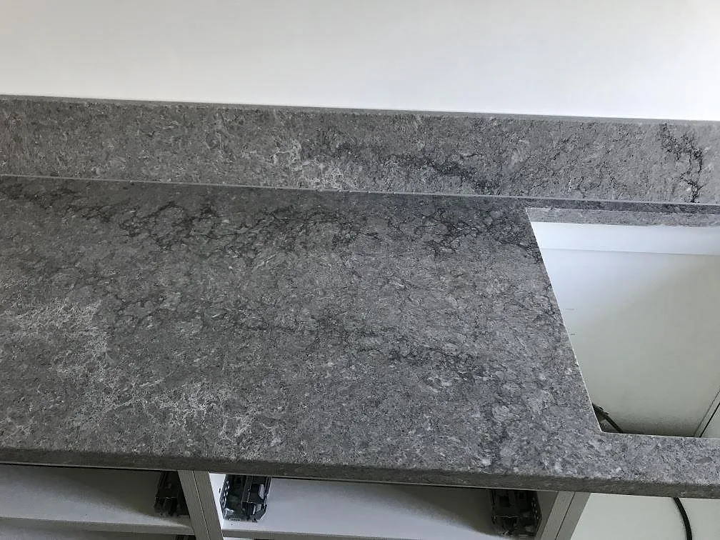 Ovanifrån syns rörelsen och den polerade ytan i en köksbänkskiva av Caesarstone Turbine Grey i Göteborg.