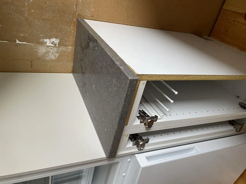 Detalj av gavel och tjocklek på 30 mm polerad Caesarstone Turbine Grey monterad på vit köksinredning i Grundsund.