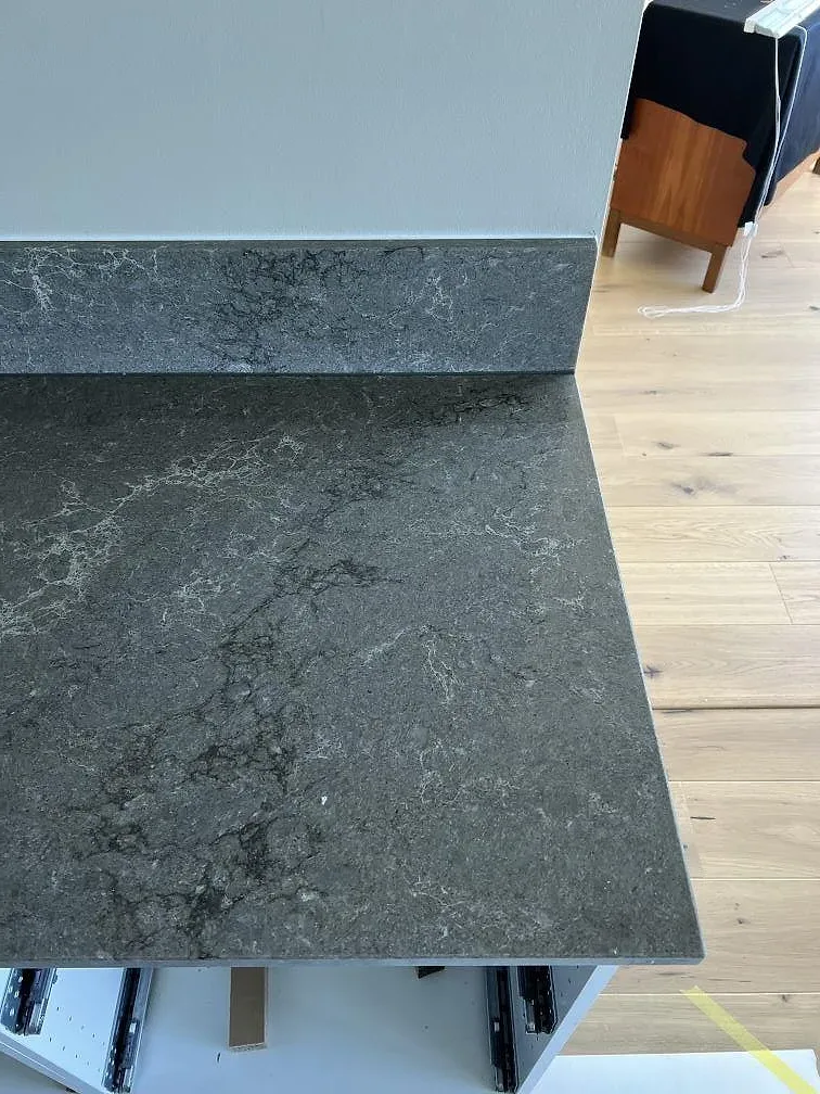 Ytdetalj av Caesarstone Turbine Grey, polerad grå komposit för köksö med ljus ådring i Helsingborg.