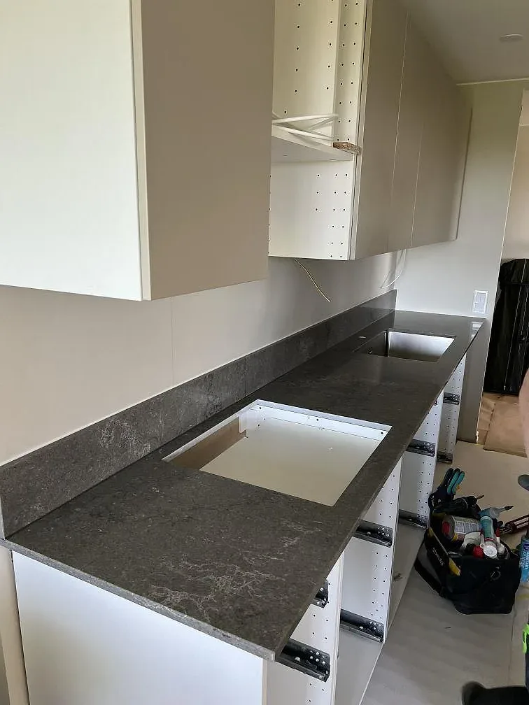 Köksbänkskiva i Caesarstone Turbine Grey, polerad komposit, monterad som grå köksö med öppning för diskho i Helsingborg.