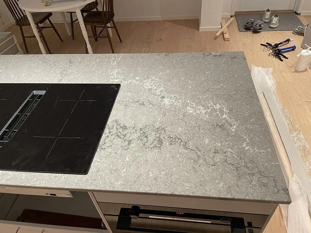 Köksö i Caesarstone Turbine Grey med induktionshäll under pågående montering i ett kök i Västra Frölunda.