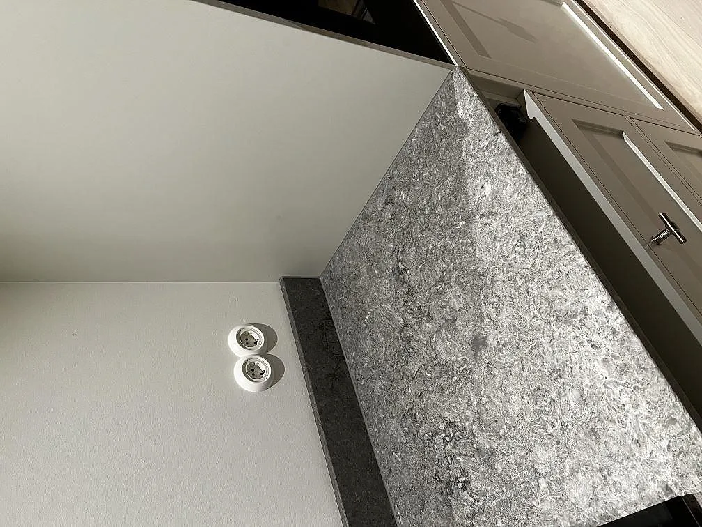 Närbild på polerad grå Caesarstone Turbine Grey med molnig ådring och stänkkant i ett kök i Västra Frölunda.