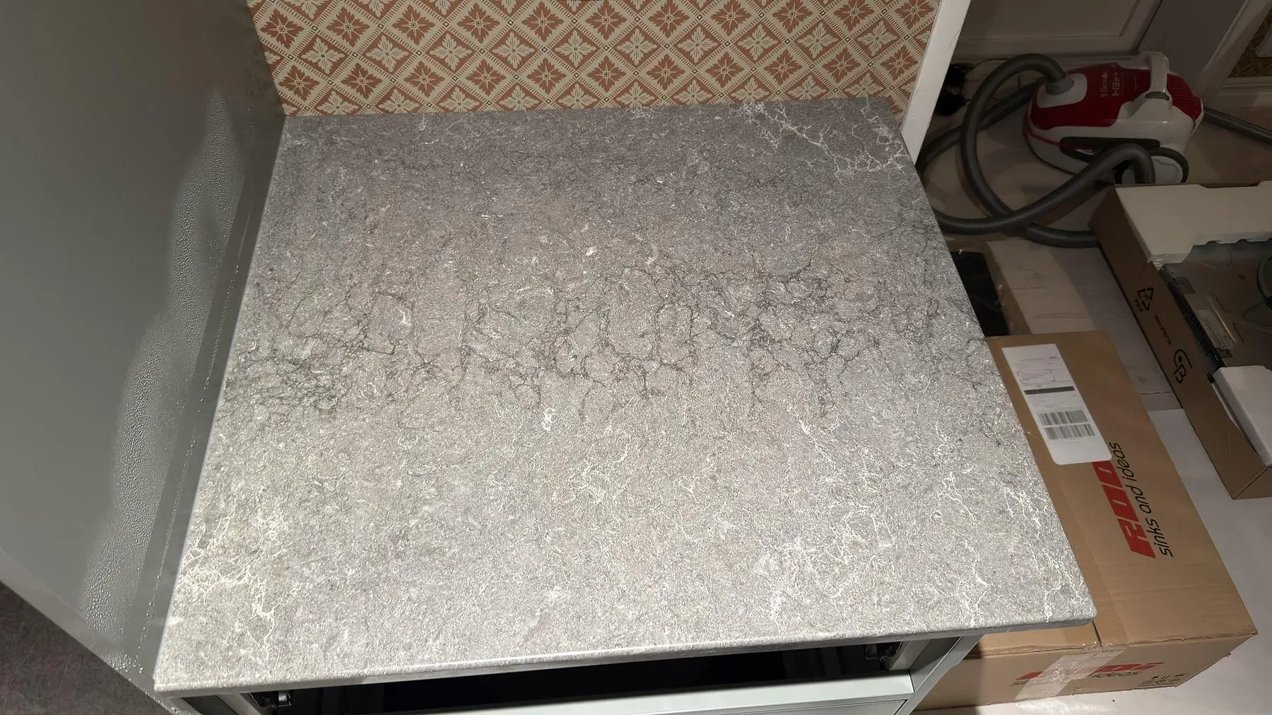 Närbild på den polerade ytan i grå Caesarstone Turbine Grey med fin vit prickning och lugn ådring i ett kök i Vallentuna.