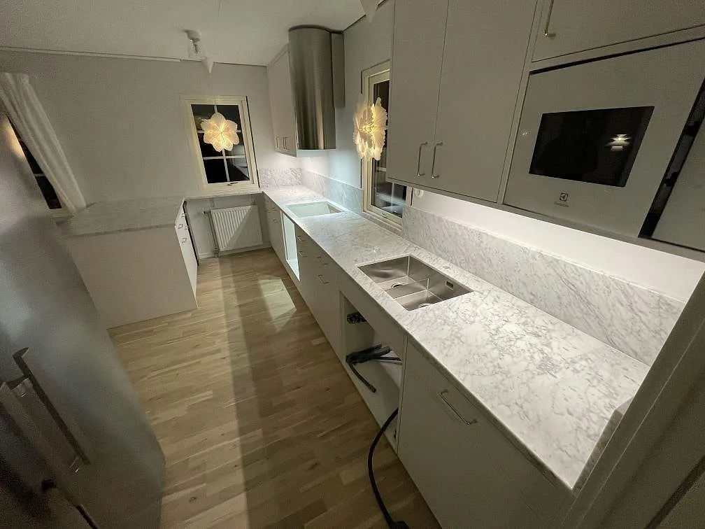Matt Carrara C-marmor som köksbänkskiva med underlimmad rostfri diskho, förberett hälluttag och stänkskydd i Avesta.