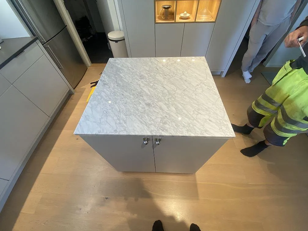 Köksöskiva i polerad Carrara C marmor, 20 mm, monterad på grå köksskåp i Bara.