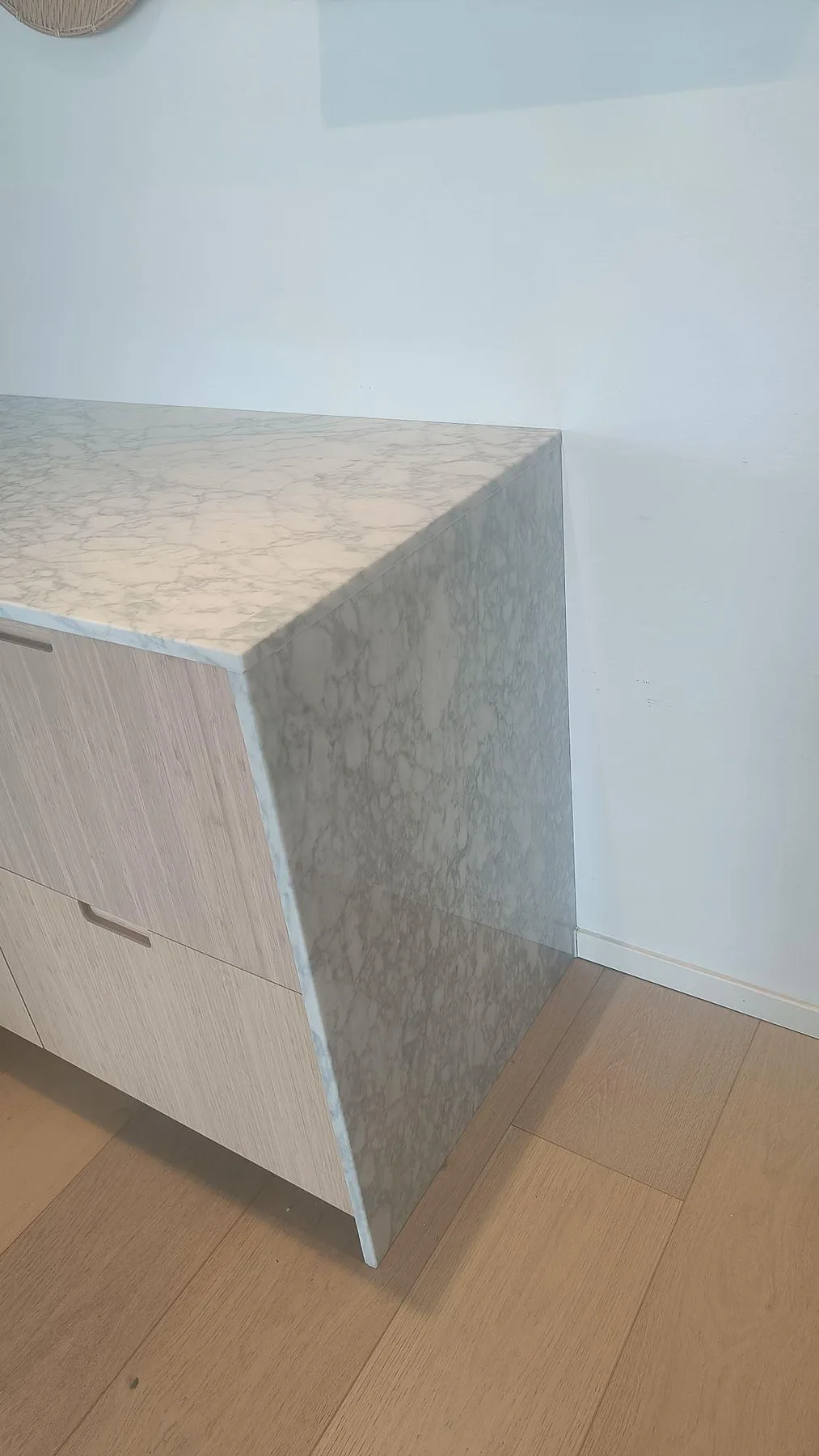 Neddragen sidobeklädnad och topp i polerad Carrara C marmor på en trätonad barenhet i Bunkeflostrand.