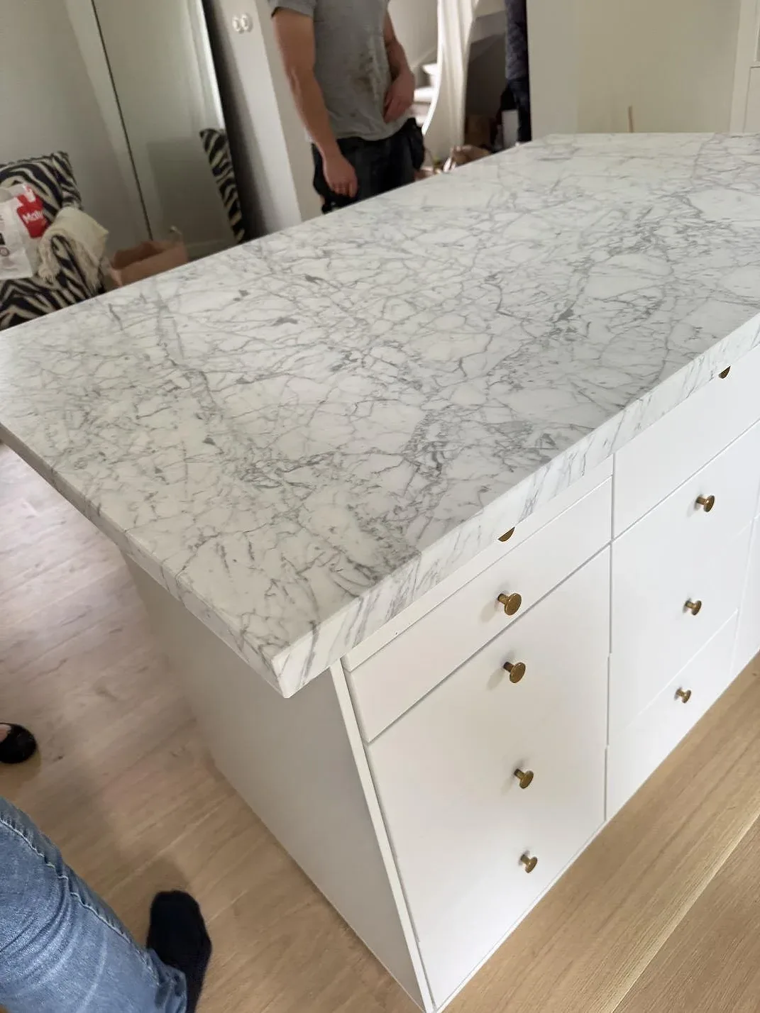 Carrara C marmor som matt köksöskiva i Falsterbo, med vit lådsektion, ljusa beslag och obruten stenyta.