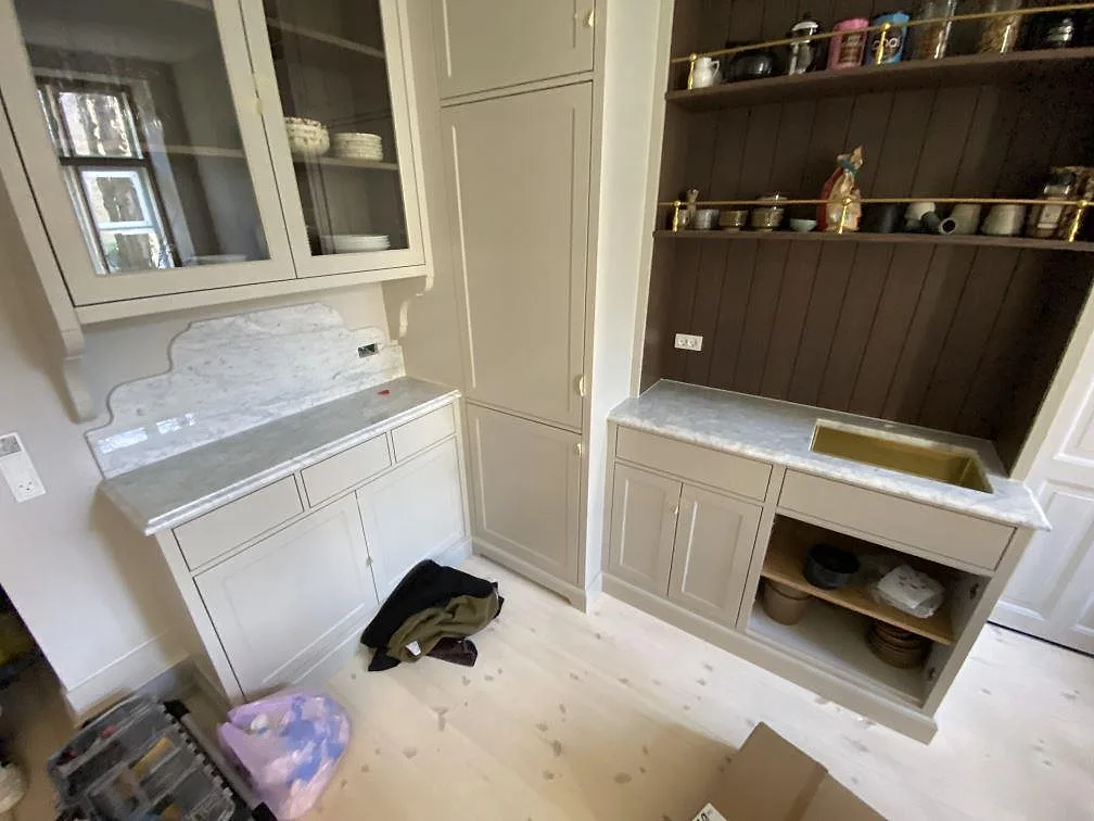 Polerad Carrara C-marmor på två köksytor med uppvikt stänkkant och vit diskho i ett kök i Frederiksberg C.