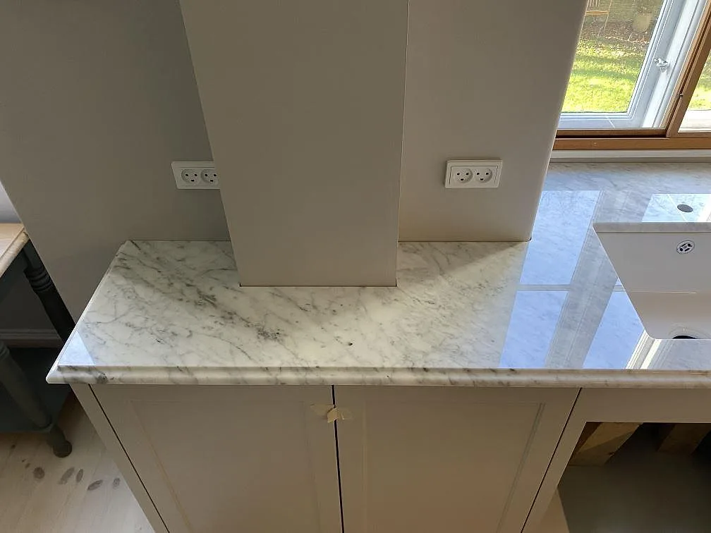 Polerad Carrara C-marmor som köksbänkskiva runt hörn och fönsteryta i Frederiksberg C.
