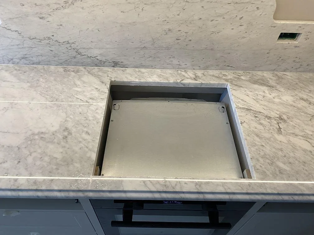 Polerad Carrara C-marmor med hälluttag och stänkkant över ugn i ett kök i Frederiksberg C.