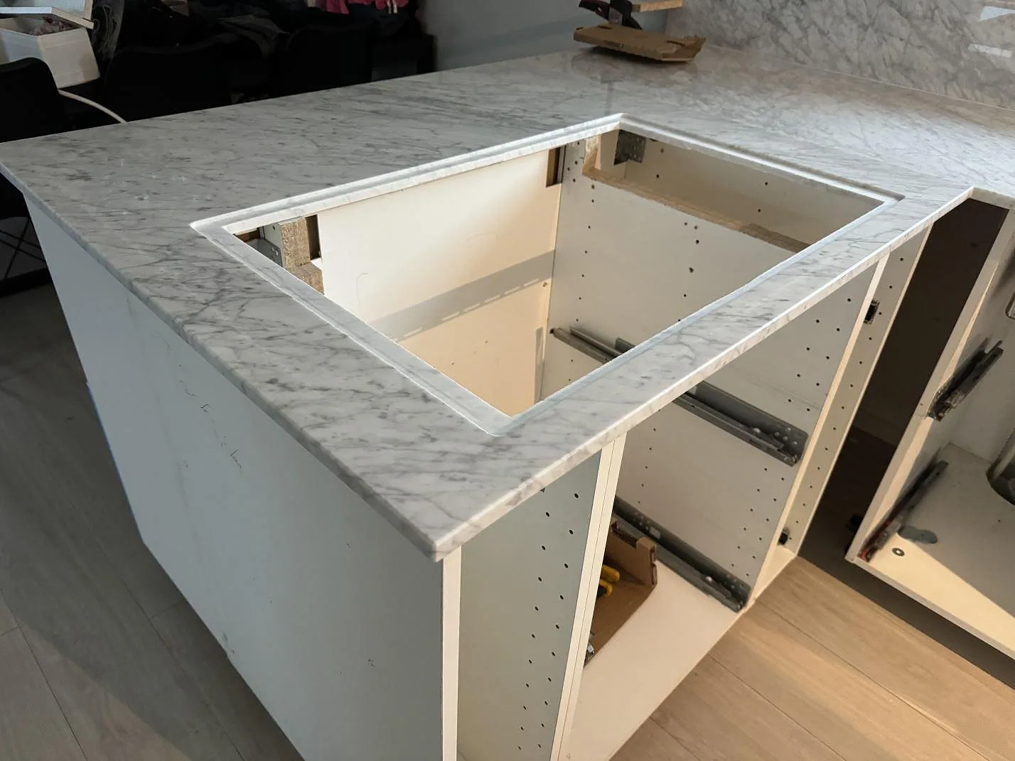 Polerad Carrara C-marmor som köksbänkskiva med underlimmad rostfri diskho, stänkkant och ljus ådring i Höganäs.