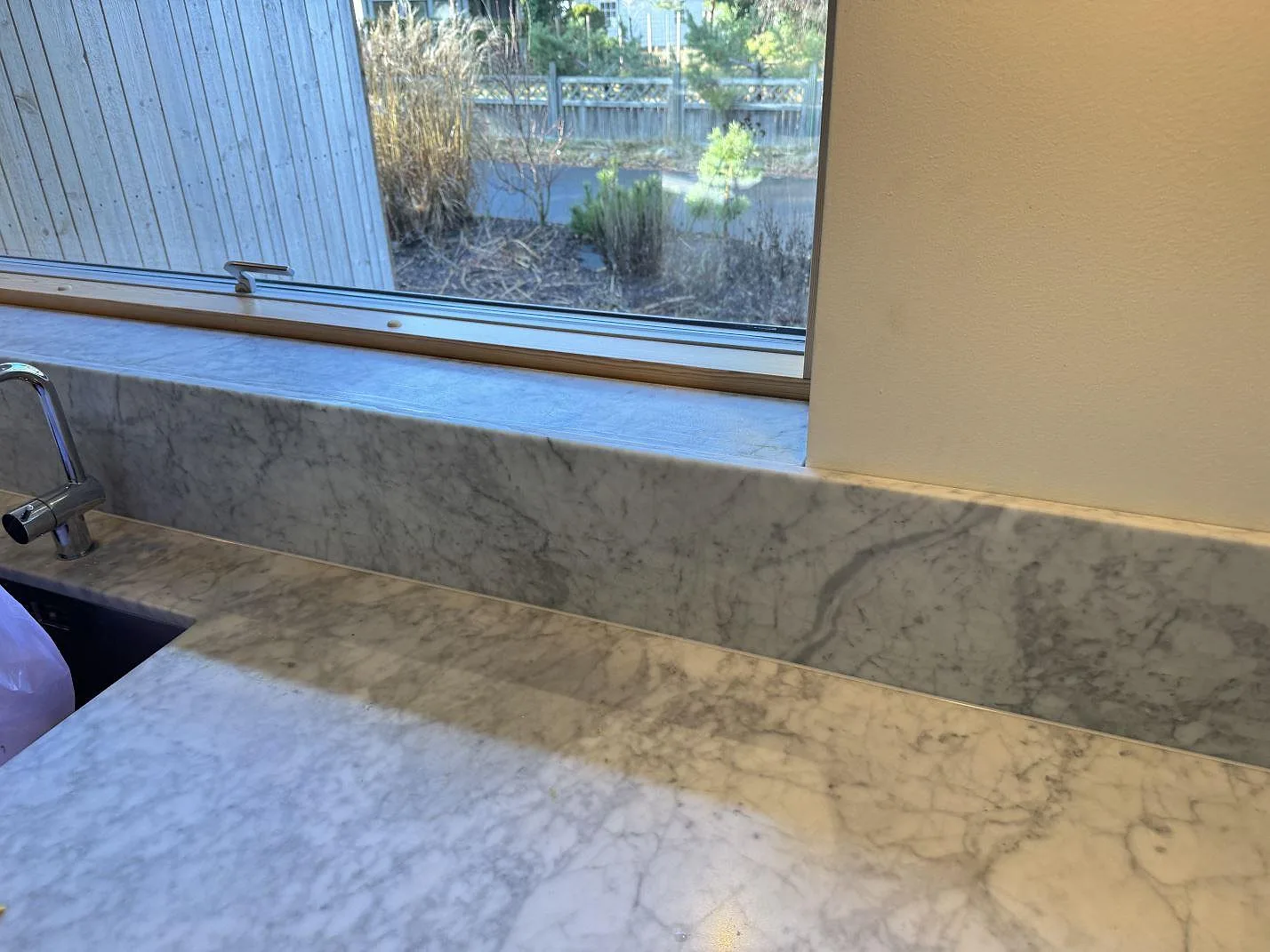 Köksbänkskiva i Carrara C marmor, matt, med kökskran och fönsterbänk i samma sten i Höllviken.