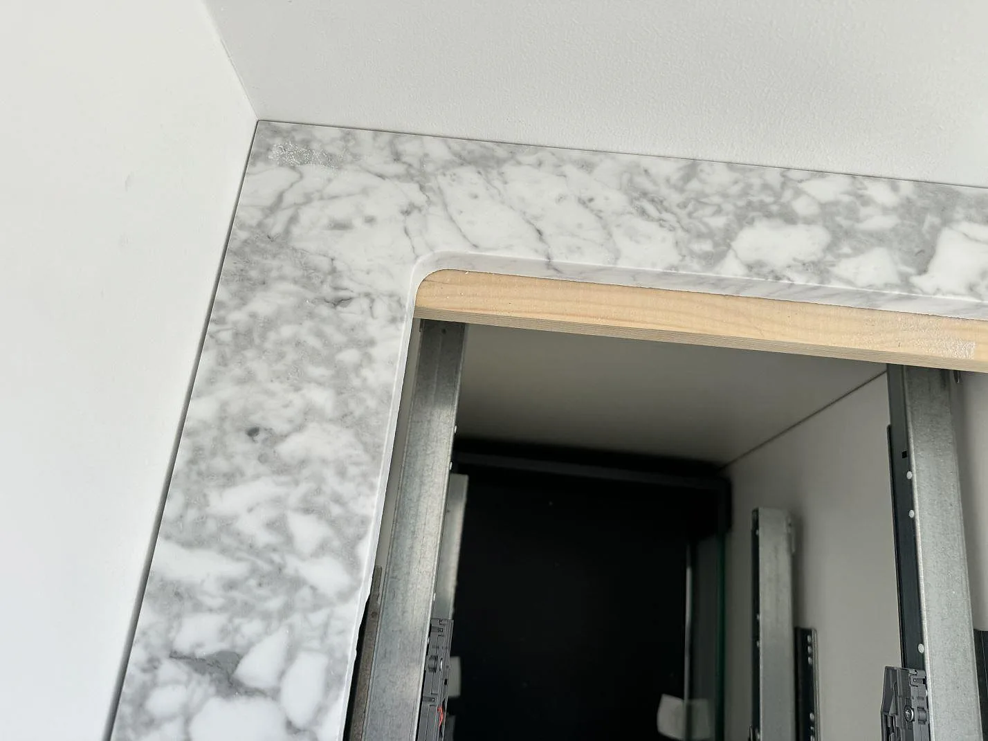 Carrara C marmorbänkskiva i badrum, polerad yta med tydlig ådring kring kommodens öppning i Lomma.