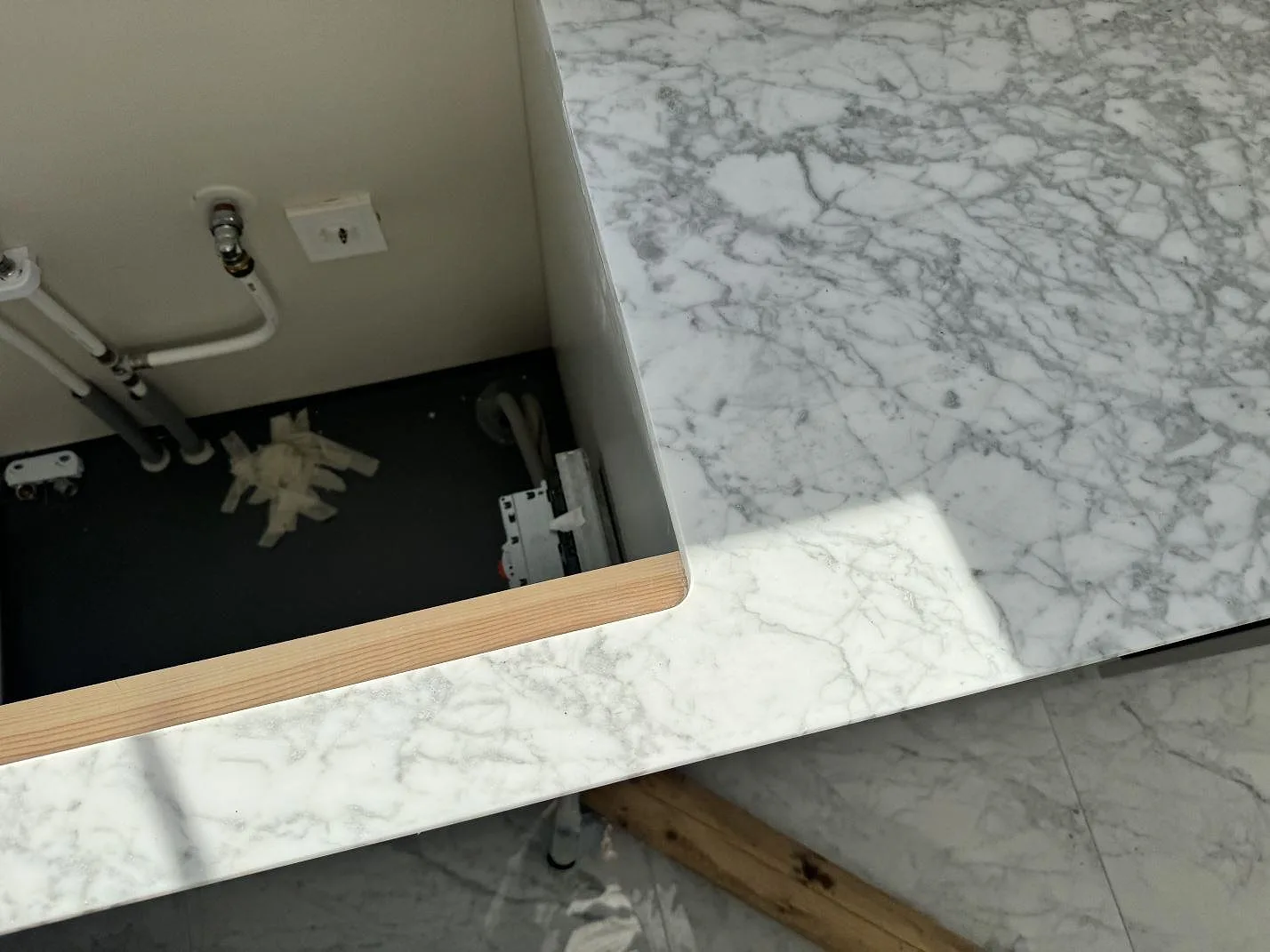 Närbild på ådringen i polerad Carrara C marmor vid kommodöppningen i ett badrum i Lomma.