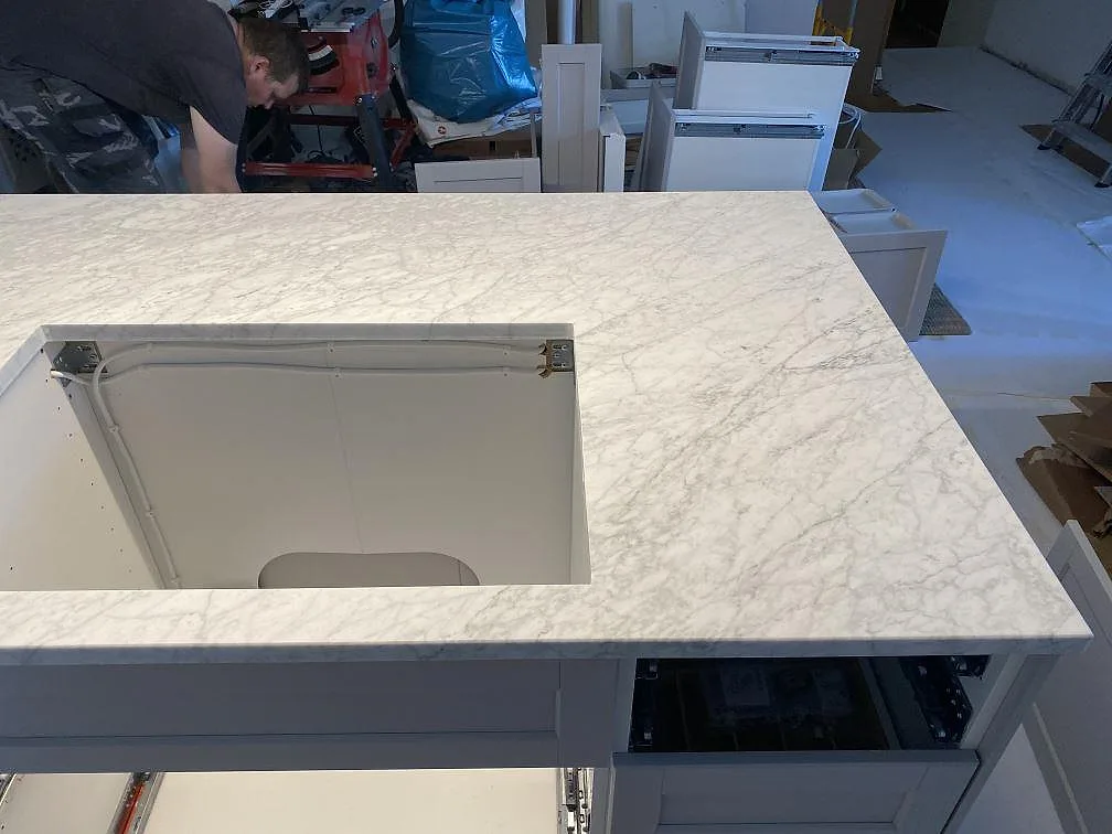 Köksö i Carrara C marmor med urtag, fotograferad ovanifrån under montering i ett kök i Malmö.
