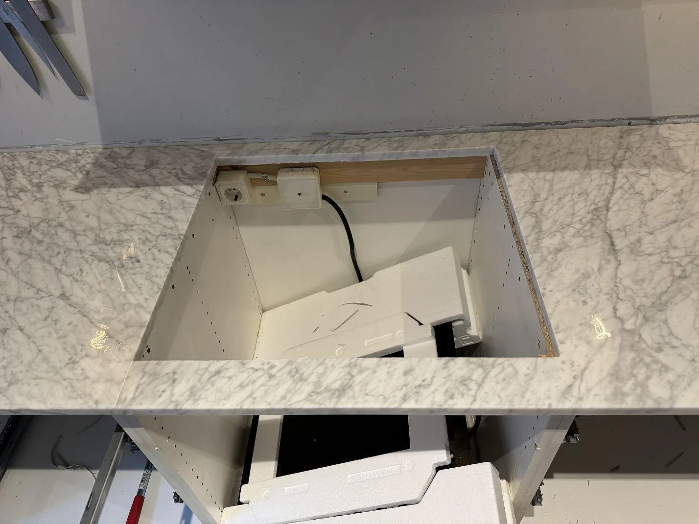 Lång bänkyta i polerad Carrara C marmor med grå ådring och rostfri diskho i Malmö.