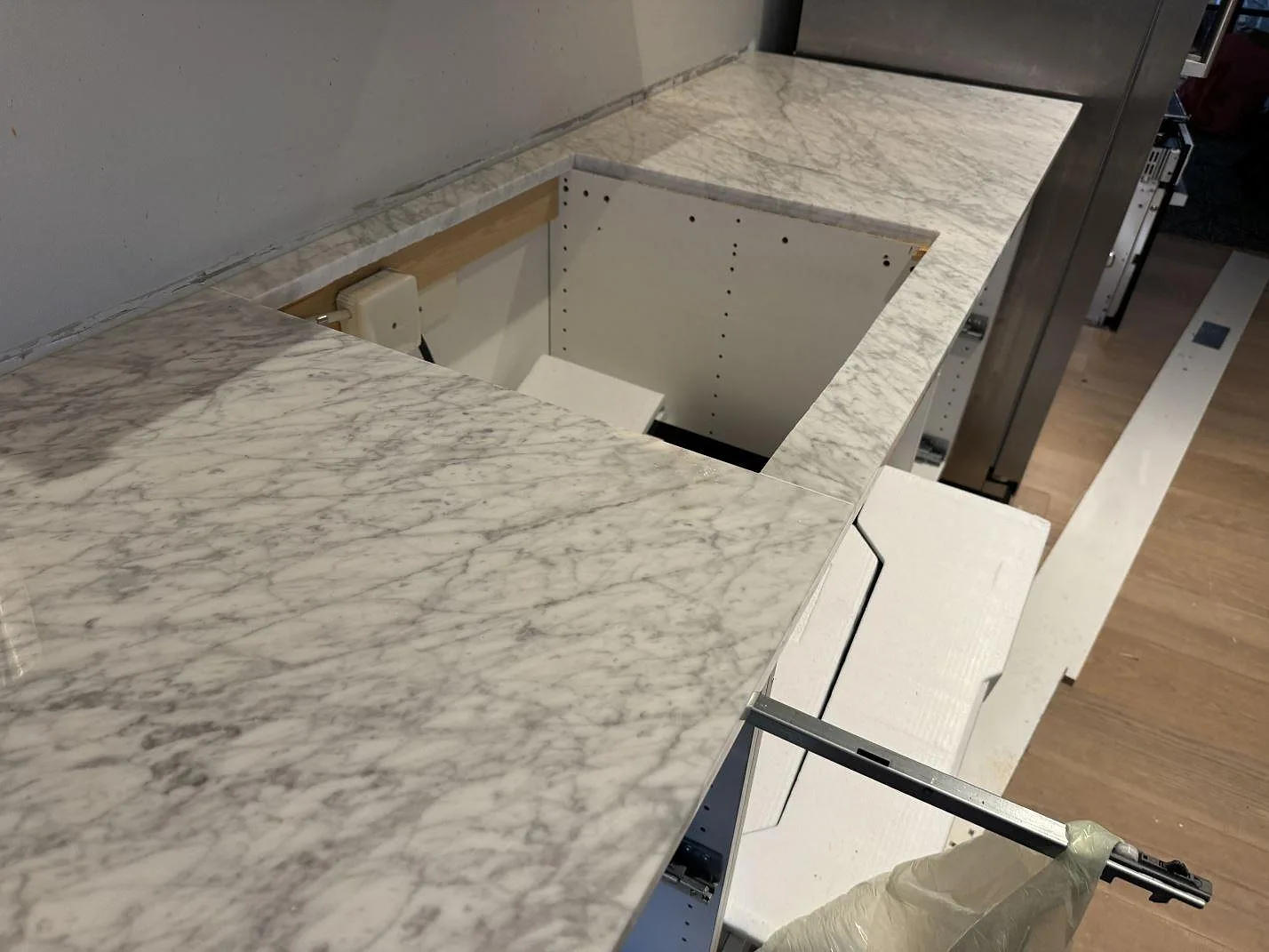 Närbild på underlimmad rostfri diskho i en polerad Carrara C marmorskiva i ett kök i Malmö.