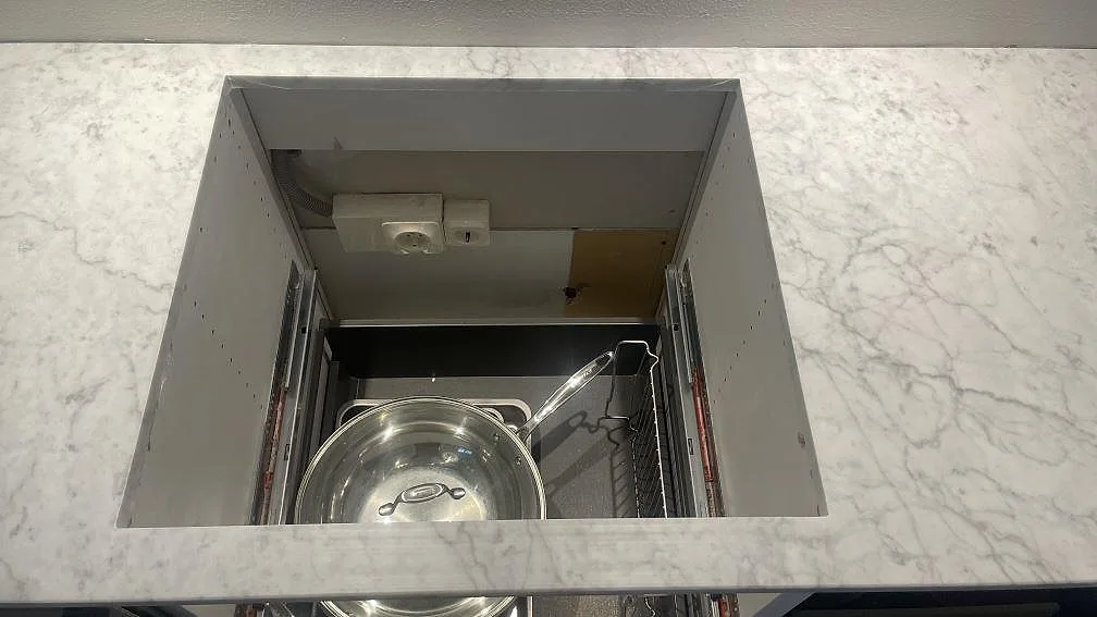 Hällöppning i polerad Carrara C marmor med tydlig grå ådring i ett vitt kök i Malmö.
