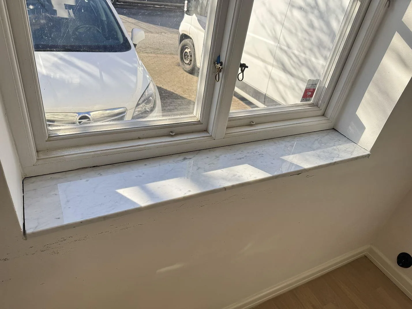 Sidovy av polerad fönsterbänk i Carrara C-marmor med ljusgrå ådring i Malmö.