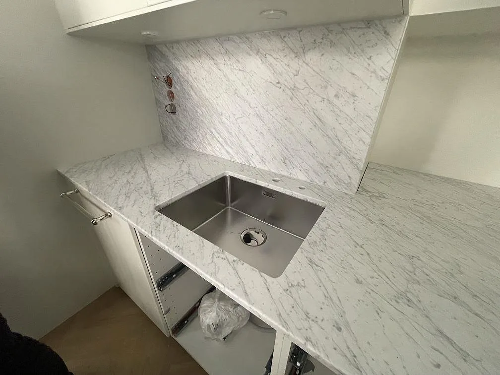 Matt Carrara C-marmor som köksbänkskiva med rostfri diskho och stänkskydd i Stockholm.