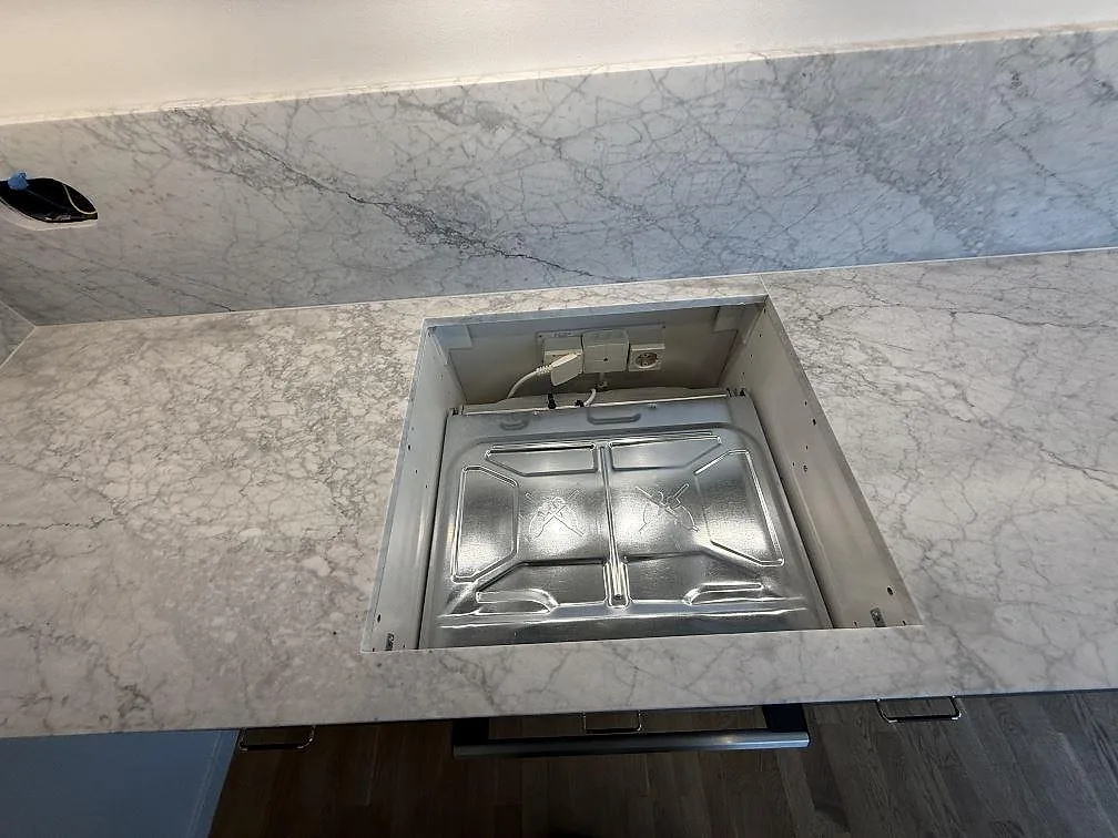 Matt köksbänkskiva i Carrara C marmor med utskärning för spishäll och stänkskydd i Stockholm.