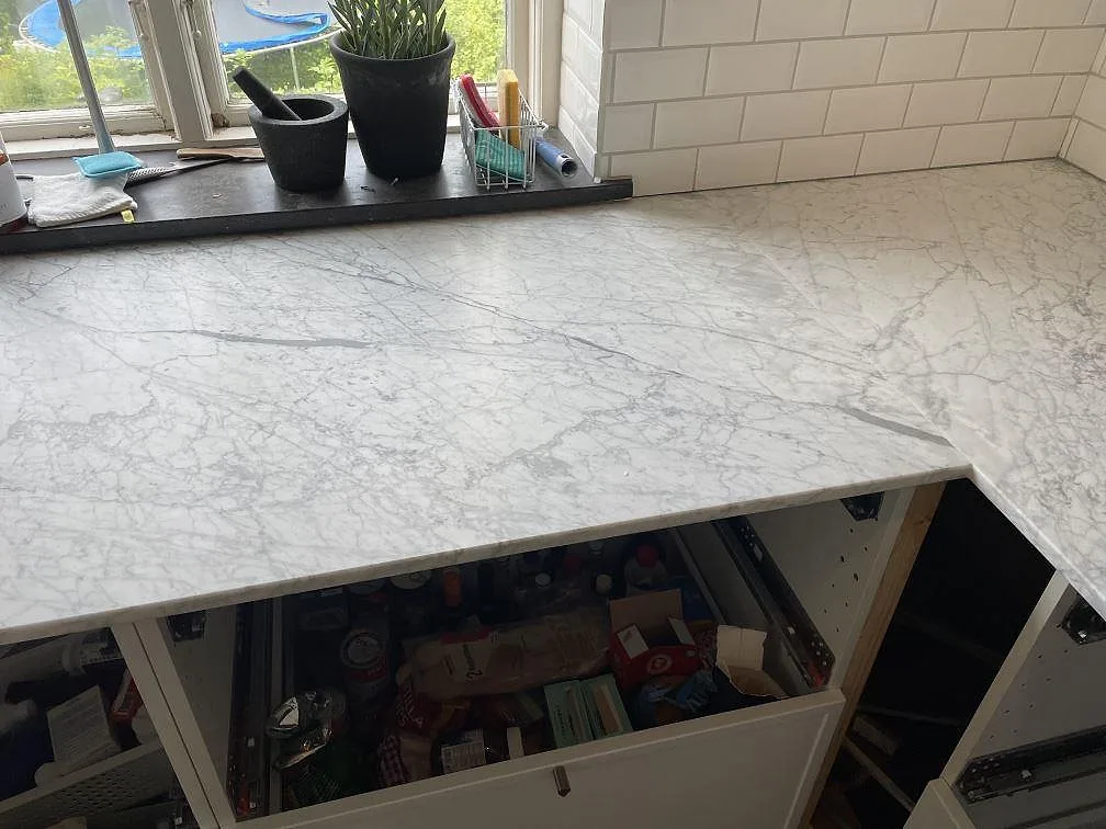 Köksbänkskiva i Carrara C marmor, matt, med hörnretur, fönster och tydlig grå ådring i Trelleborg.