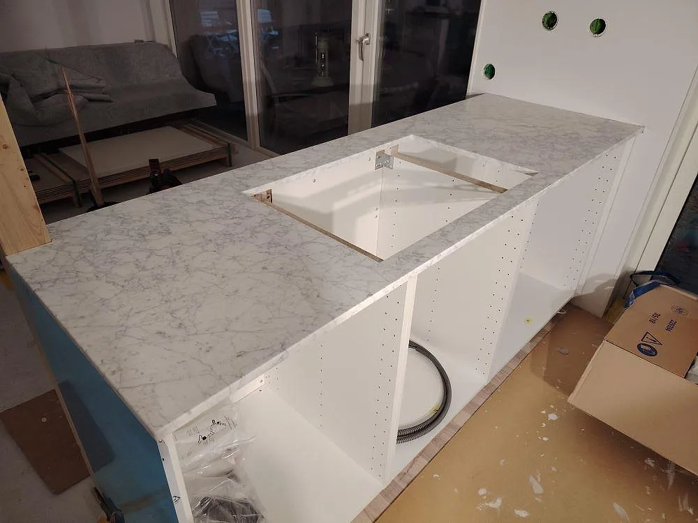 Carrara C marmor som matt köksbänkskiva med urtag för diskho på öppna vita stommar i Västervik.