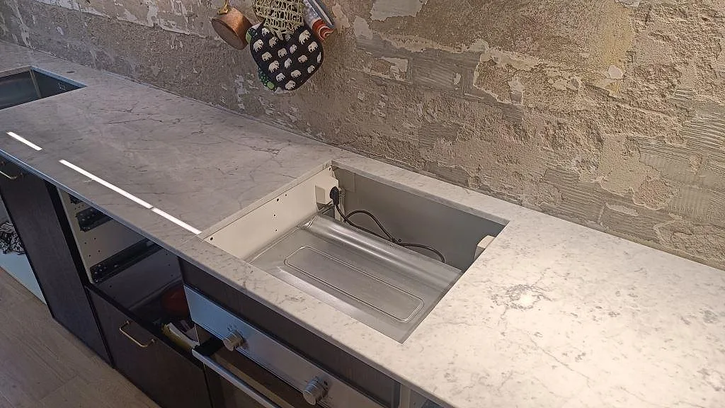 Polerad Carrara C marmorbänkskiva med rektangulärt urtag och ljus grå ådring i ett kök i Västra Frölunda.