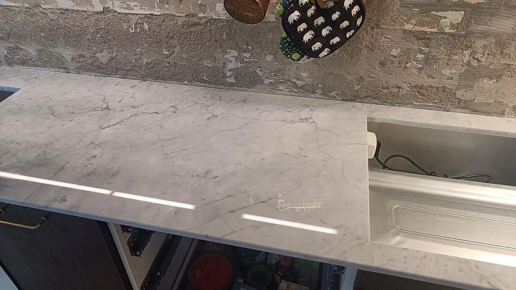 Detalj av polerad Carrara C köksbänkskiva med större rektangulärt urtag och blank yta i Västra Frölunda.