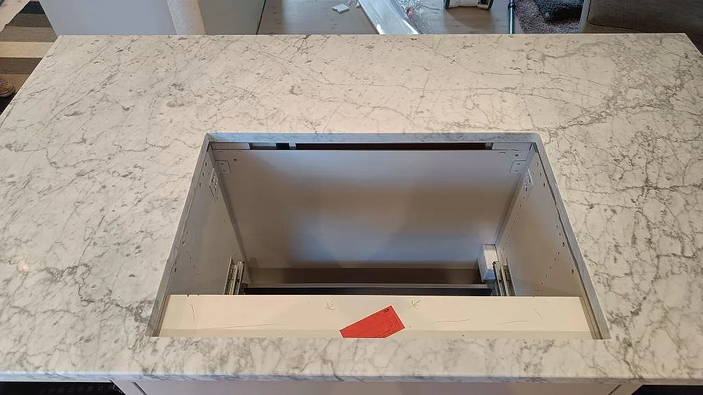 Toppvy av Carrara C marmorbänk med rektangulärt urtag och tydlig grå ådring i ett kök i Vejbystrand.