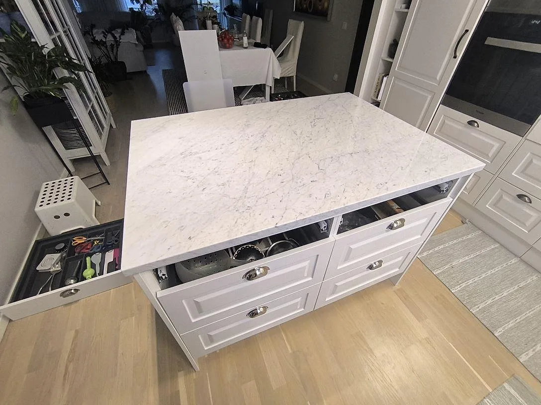 Köksö med köksbänkskiva i polerad vit Carrara C marmor, 30 mm, på vit lådinredning i Danderyd.