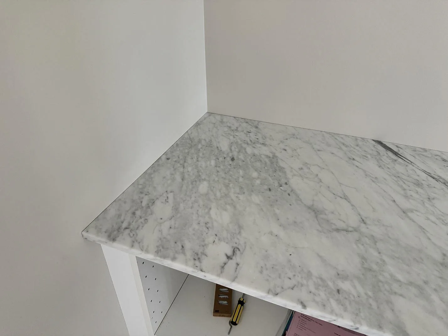Hörndetalj av 20 mm matt Carrara C marmor på bänkskiva mot ljusa väggar i Klippan.