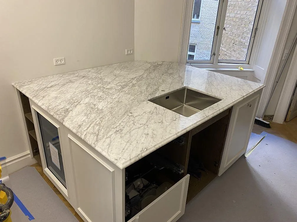 Köksbänkskiva i matt Carrara C marmor med underlimmad rostfri diskho och rundad hörnform i København Ø.