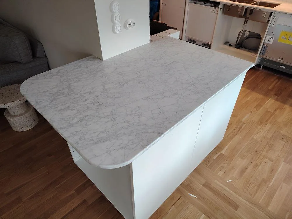 Halvö med rundade hörn i matt Carrara C marmor som köksbänkskiva i Saltsjö Boo.