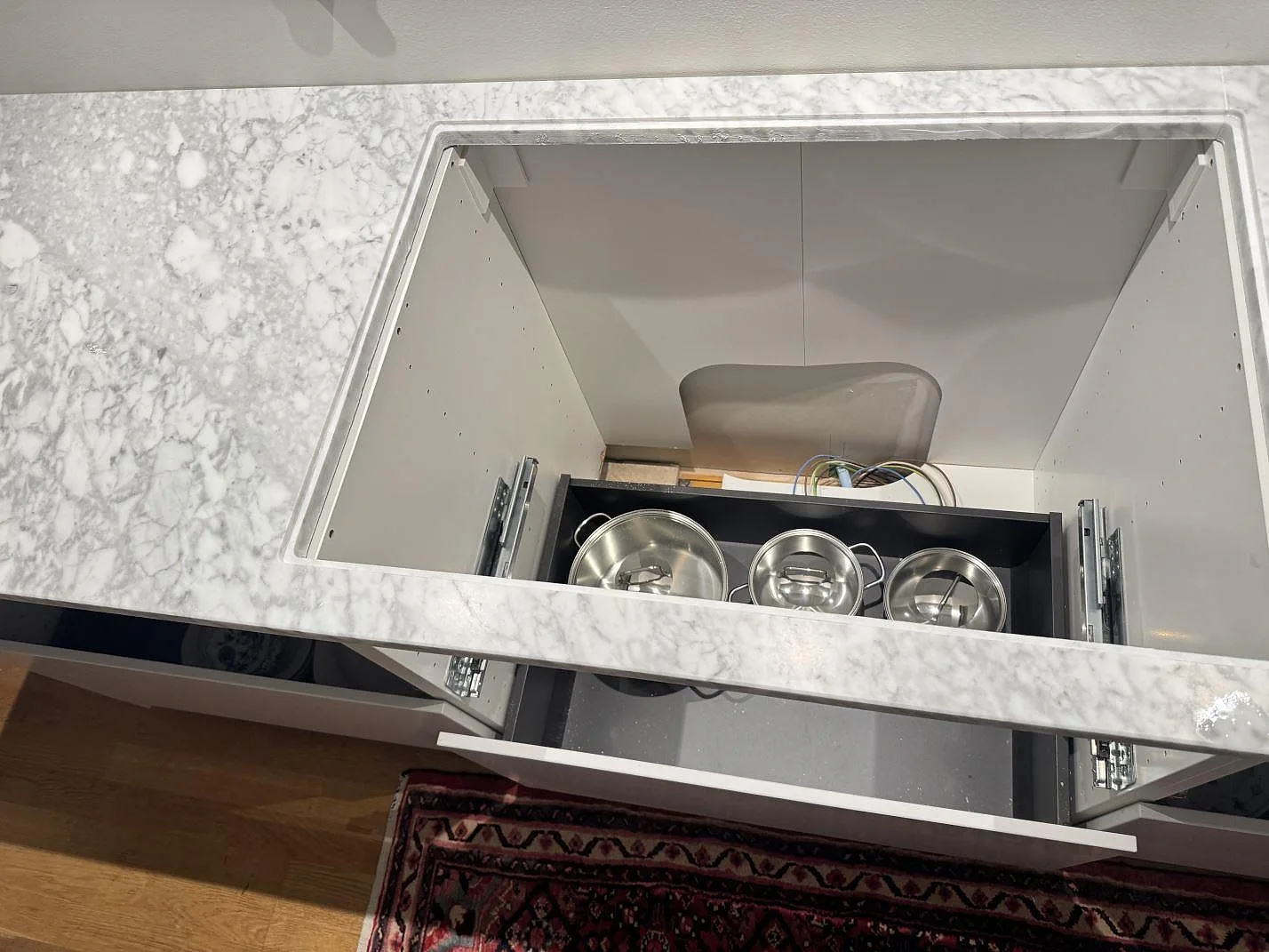 Köksbänkskiva i matt Carrara C marmor med stor öppning för häll och ljus stenådring i Stora höga.